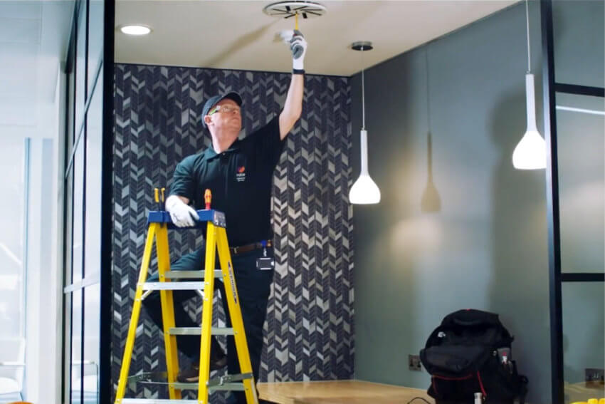 Mitie engineer checking a ceiling ventilation fanfan