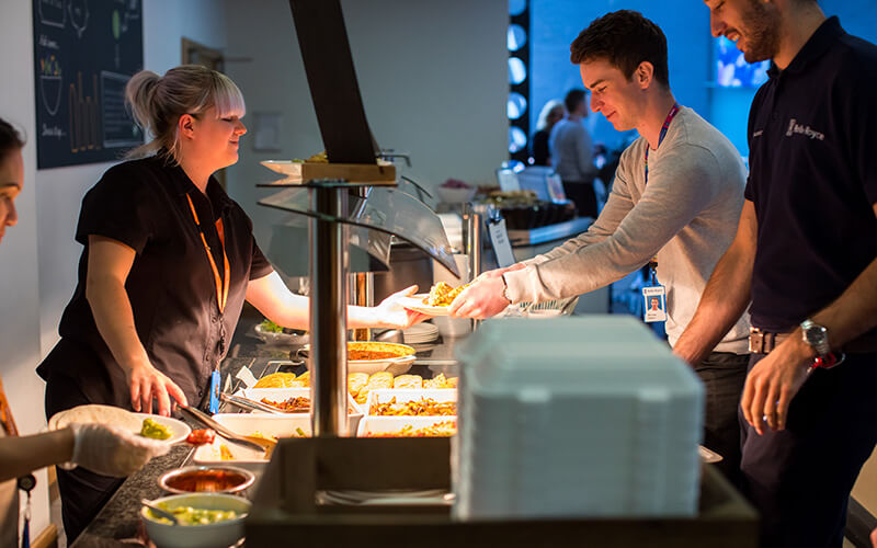 Hot food being served and chosen at a catering buffet