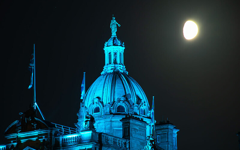 Top of a building lit up by blue lights at night