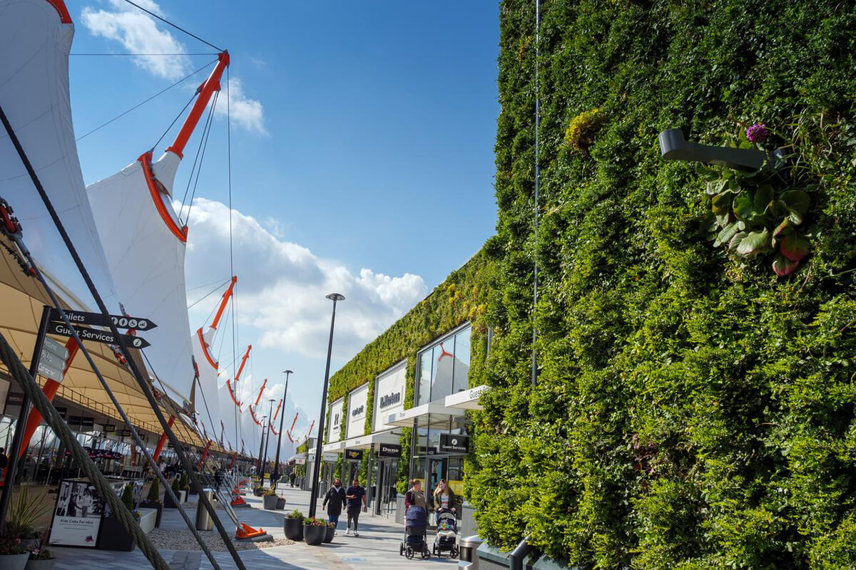 The exterior of a building with a living green wall, created by Biotecture