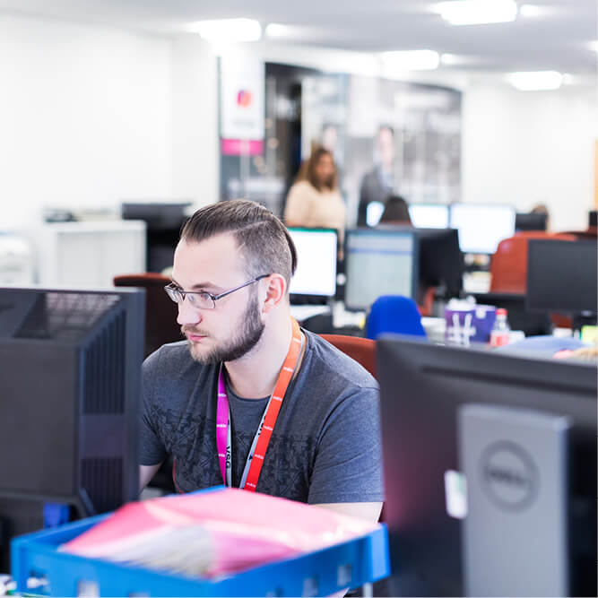 Mitie security employees working at computers in an office environment
